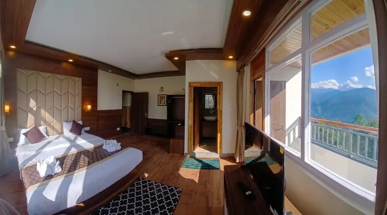Wide view of an executive room with the balcony doors open to the hills