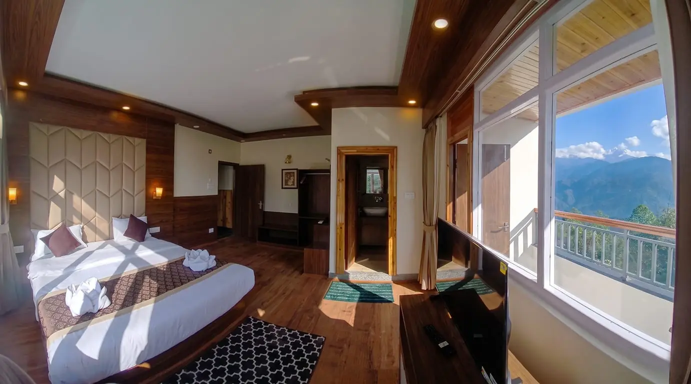 Deluxe Executive room with a wide balcony opening onto the Kanchenjunga range