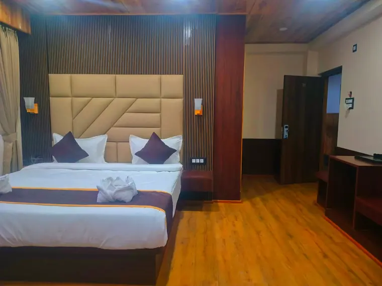 Deluxe room with a padded headboard and turned-down bed