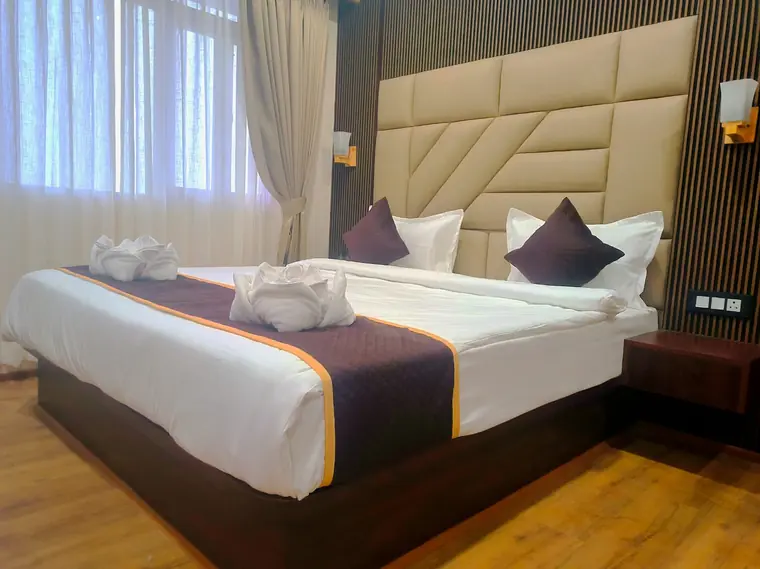 Deluxe room bed beside a bright window